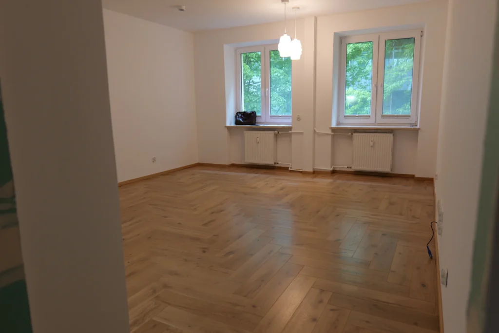 Mieszkanie z wymienionymi pionami: jodełka w salonie, wzorzysta płytka w korytarzu
